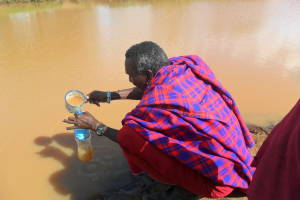 A pastoralist collects drinking water from a contaminated water source in the northern part of Tanzania. He is one of the 650 millions of people without access to safe water. 