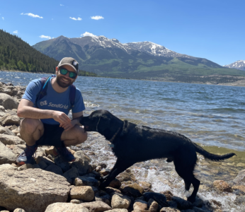 Kevin Mullan, climate activist, poses for a photo with his dog in front of a lake