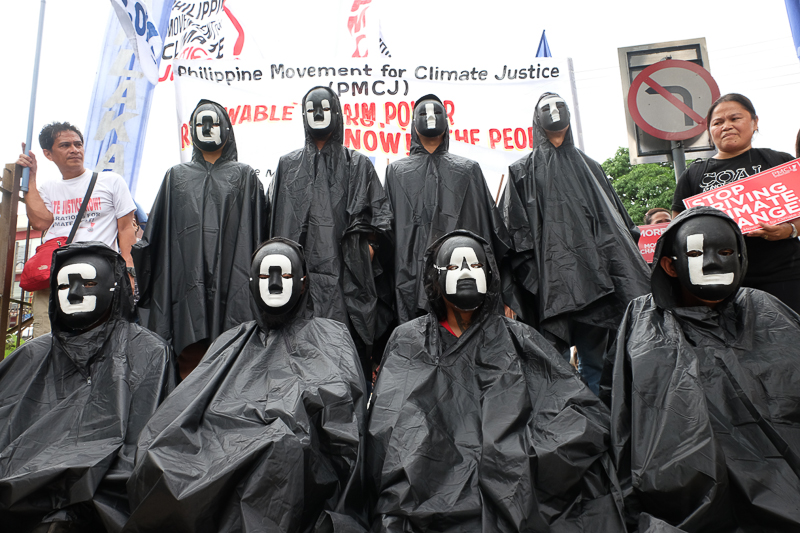Climate activists dressed as "coal spectres" to symbolize the menace of dirty energy during their peaceful protest at an international coal industry summit in the Philippines in front of New World Hotel and Dusit Thani. Photo: AC Dimatatac 