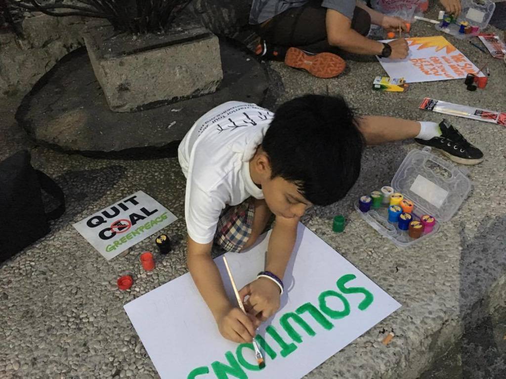 Cedric and other volunteers painting placards that for the march. Photo: Jenny Tuazon